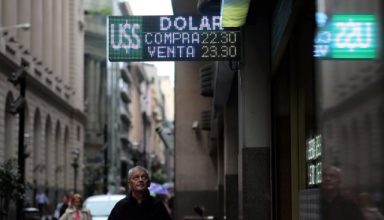 A man looks at an electronic board showing currency exchange rates in Buenos Aires' financial district, Argentina May 8, 2018. REUTERS/Marcos Brindicci