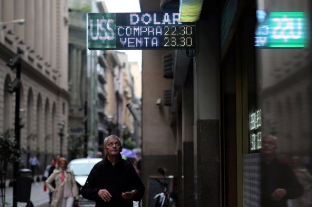 A man looks at an electronic board showing currency exchange rates in Buenos Aires' financial district, Argentina May 8, 2018. REUTERS/Marcos Brindicci