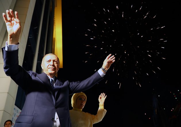 ANKARA, TURKEY - JUNE 25: President of Turkey and leader of the Justice and Development Party (AK Party) Recep Tayyip Erdogan (L) and his wife Emine Erdogan (R) greet the crowd from the balcony of the ruling AK Party's headquarters as fireworks illuminate the sky following his election success in presidential and parliamentary elections in Ankara, Turkey on June 25, 2018.
(Photo by Kayhan Ozer/Anadolu Agency/Getty Images)