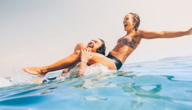 Man carrying his girlfriend on shoulders in the sea.