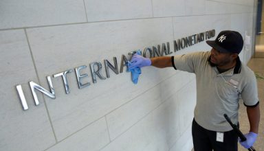 A facilities maintenance staff member cleans signage at International Monetary Fund headquarters building during the IMF/World Bank annual meetings in Washington, U.S., October 14, 2017. REUTERS/Yuri Gripas
