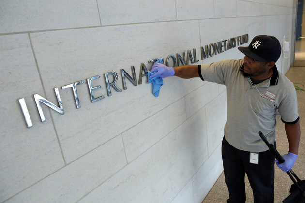 A facilities maintenance staff member cleans signage at International Monetary Fund headquarters building during the IMF/World Bank annual meetings in Washington, U.S., October 14, 2017. REUTERS/Yuri Gripas