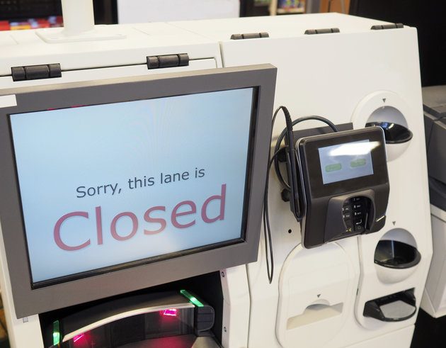 A supermarket self-checkout lane machine till with a closed sign displayed on the screen. Also known as a SACAT.
