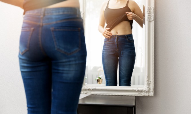 woman-checking-her-body-in-front-of-mirror-picture-id665438886 (1)