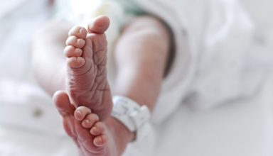 Newborn baby boy at hospital with identity tag on feet, close up
