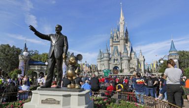 In this Wednesday, Jan. 9, 2019 photo, guests watch a show near a statue of Walt Disney and Micky Mouse in front of the Cinderella Castle at the Magic Kingdom at Walt Disney World in Lake Buena Vista, Fla. Disney is eliminating smoking areas at its theme and water parks in California and Florida. The company said in a statement on Thursday, March 28 that smoking also won't be allowed at the ESPN Wide World of Sports Complex or Downtown Disney in California starting May 1. (AP Photo/John Raoux)