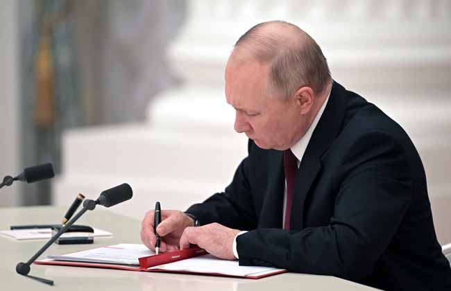 Russian President Vladimir Putin signs a document recognizing the independence of separatist regions in eastern Ukraine in the Kremlin in Moscow, Russia, Monday, Feb. 21, 2022. Russia's Putin has recognized the independence of separatist regions in eastern Ukraine, raising tensions with West. (Alexei Nikolsky, Sputnik, Kremlin Pool Photo via AP)