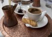 "The coffee, created in 'Briki', served with a cookie, spoon sweets and glass of water. Typical beverage greek and turkish.Taken in Thessaloniki, Greece"