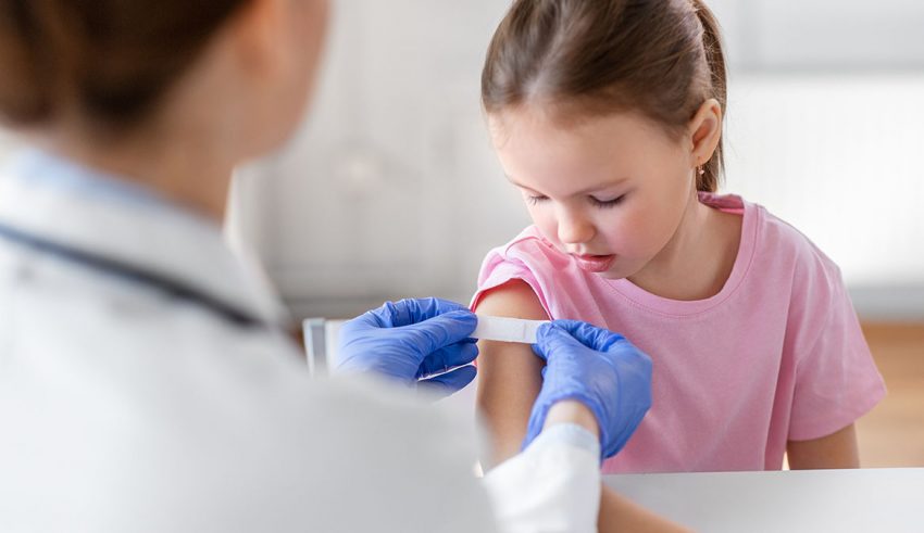 medicine, healthcare and vaccination concept - female doctor or pediatrician talking to little girl patient on medical exam at clinic
