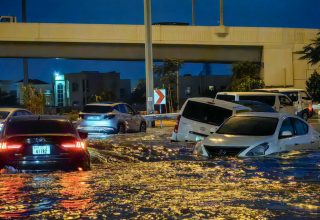 Cars drive in a flooded street following heavy rains in Dubai on April 17, 2024. Dubai, the Middle East's financial centre, has been paralysed by the torrential rain that caused floods across the UAE and Bahrain and left 18 dead in Oman on April 14 and 15. (Photo by Giuseppe CACACE / AFP)
